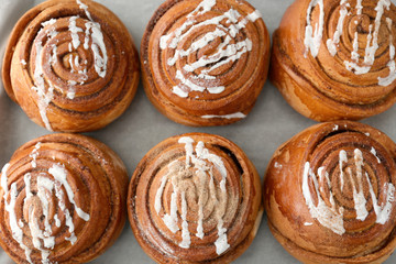 Delicious cinnamon buns on table, top view