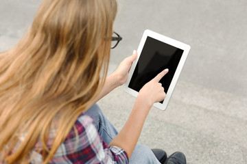 Unrecognizable woman using digital tablet outdoors