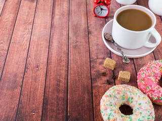 Donuts and coffee on wooden table. Top view with copy space