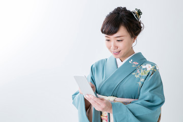 Obraz premium 携帯電話を見る着物姿の女性（笑顔） 