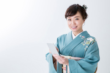 Obraz premium 携帯電話を見る着物姿の女性（笑顔） 