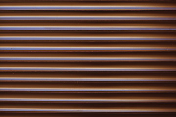 Surface textured horizontal, striped, brown facing wall, siding.