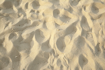 Sand on the beach on a clear and sunny day, barefoot.
