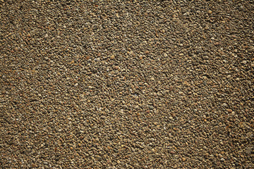 Sand texture motley pebbles on the ground, asphalt.