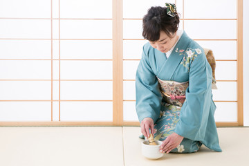 抹茶をたてる着物姿の女性
