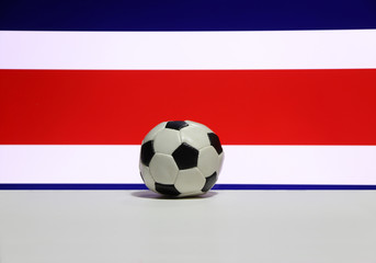 Small football on the white floor with white red and blue color of Costa Rican nation flag background. The concept of sport.