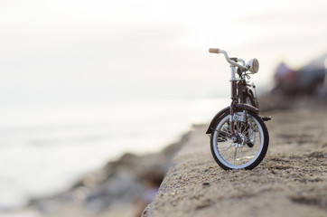 Fototapeta na wymiar bicycle toy on beach sunset time holiday