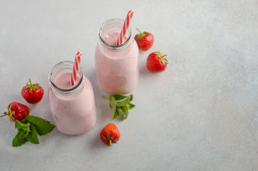 Strawberry milkshake on a gray concrete background, selective focus, copy space.