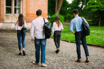 Fototapeta premium Rear view of students walking together in campus outdoors