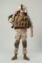 Soldier in camouflage holding rifle