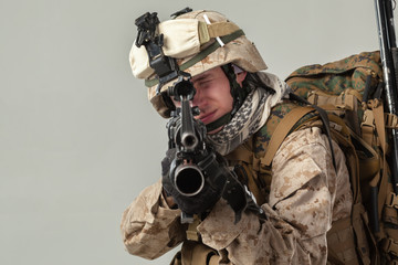 Soldier in camouflage holding rifle