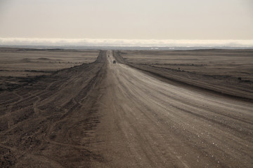 Fototapeta szeroka droga biegnąca przez pustkowie ginąca daleko na rozmywającym się horyzoncie obraz