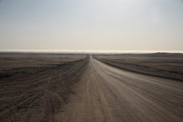 Fototapeta szeroka droga biegnąca przez pustkowie ginąca daleko na rozmywającym się horyzoncie obraz
