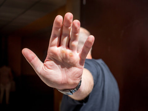 Man closes his face with  hand. Man wants to remain unidentified. Problems with the law_