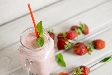 Strawberry milkshake with the scattered ripe berries