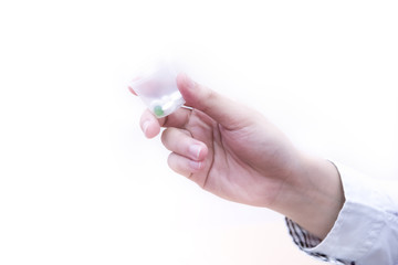 The doctor giving  dosage cup of medication.