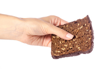 A piece of bread with seeds in a hand on a white background isolation