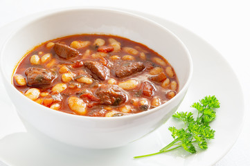 mutton stewed in tomato red wine gravy   with white beans decorated with parsley