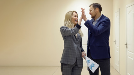 Businesswoman is talking with a partner walking down the corridor