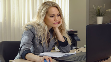 tired blonde female falls asleep at the workplace in office.