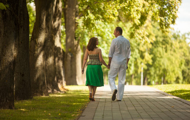 Fototapeta premium man and woman on a walk in the city park, family happiness