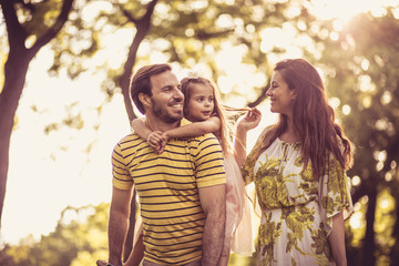 Fototapeta premium Happy family with little girl walking trough nature.