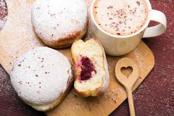 Classic donuts with powdered sugar, on wooden background