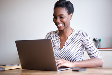 happy woman working on laptop from home office