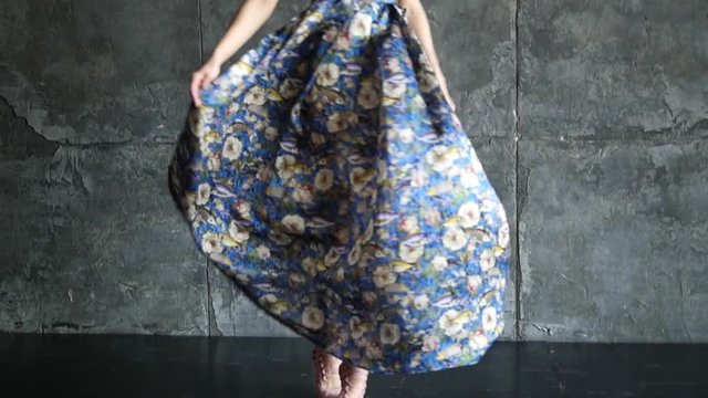 Beautiful young girl is dancing in a summer dress in high heels