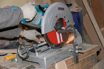 Work cuts metal. Metal cutting miter saw. Sparks when cutting metal.