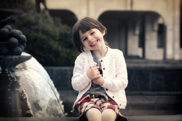 Adorable little girl's portrait by fountain