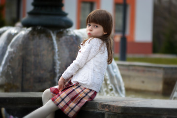 Little girl posing at a fountain