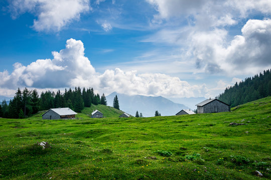 Am Gipfel auf einer Alm mit H&uuml;tten und Wiese am Vormauerstein in &Ouml;sterreich mit Wolken am blauen Himmel