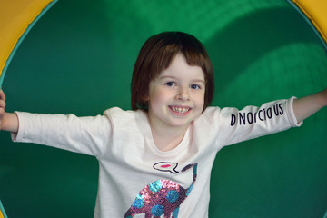 Smiling girl on a green slide