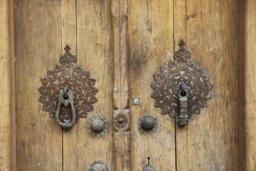 stare drewniane drzwi z ozdobnym mosiężnym okuciem