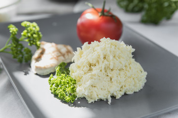 Cabbage salad with a sprig of parsley on a gray plate on a white table