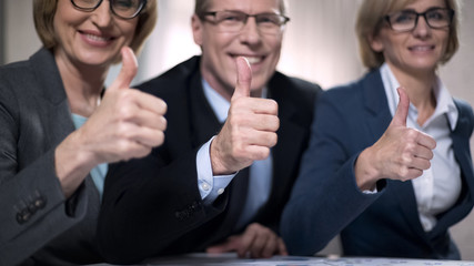 Happy business people with thumbs up, satisfied with successful presentation