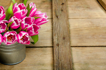 Pink tulip bouquet on retro wooden background, copy space