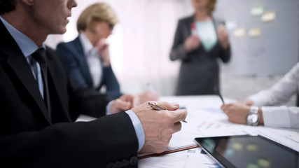 Man taking notes during his colleague presentation in office, teambuilding