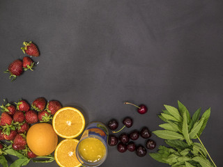 flat lay of fresh healthy food with mint cherry and orange juice copy space on blackboard
