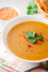 Red lentil cream soup on gray stone background