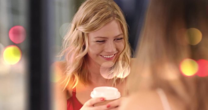 Close view of beautiful blonde girl being social with girlfriend drinking inside cafe, Closeup of cute caucasian girl chatting with friend in city coffee store, 4k
