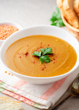 Red lentil cream soup on gray stone background