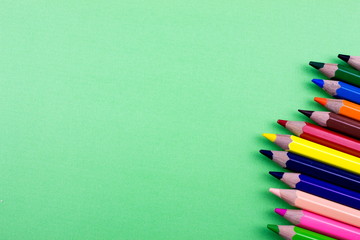 Pencils set on green tone color paper. Empty space for text and design. Minimalism concept.