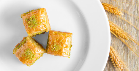 three slices of baklava and wheat heads on the plate