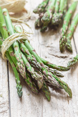 Bunch of organic green asparagus on an old wooden table