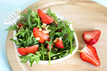 Salad of arugula and strawberries with pine nuts. Top view. Copy space.