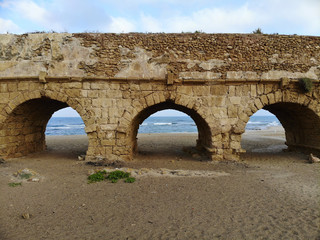 Fototapeta na wymiar Aqueduct on the beach in Caesarea