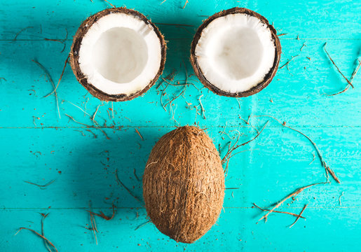 Half and whole coconut on a blue background with peel