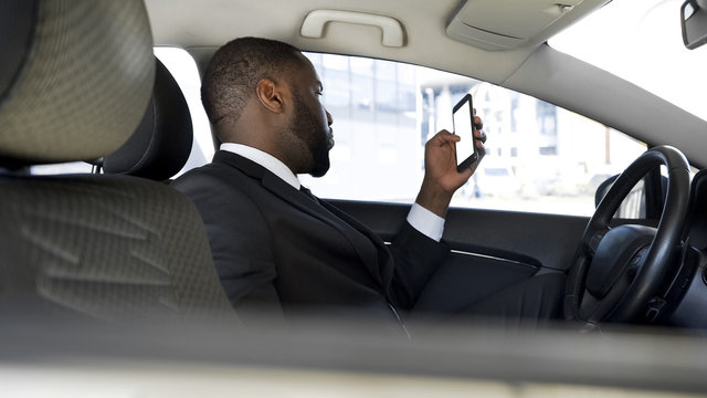 Man Stuck In Traffic Jam, Bored Scrolling News Application On His Smartphone